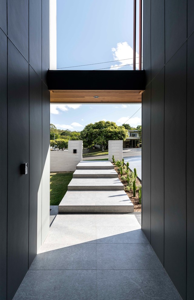 Photo of a contemporary entry hall in Brisbane with black walls and grey floor.