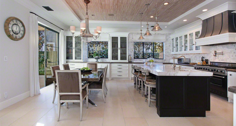 Mid-sized transitional galley medium tone wood floor enclosed kitchen photo in Boston with an undermount sink, beaded inset cabinets, white cabinets, marble countertops, white backsplash, stone tile backsplash, stainless steel appliances and an island