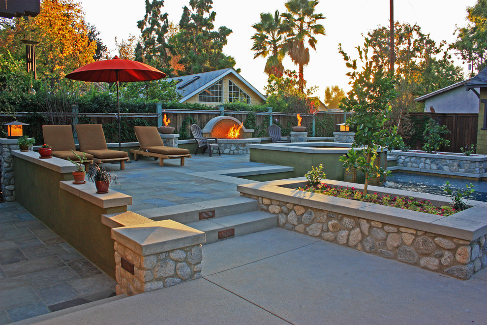 Inspiration for a large arts and crafts backyard custom-shaped pool in Los Angeles with concrete pavers and a hot tub.