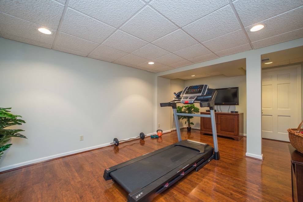 Inspiration for a mid-sized traditional multipurpose gym in Other with grey walls, dark hardwood floors and brown floor.