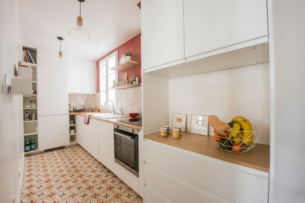 Inspiration for a mid-sized midcentury l-shaped separate kitchen in Paris with a double-bowl sink, white cabinets, wood benchtops, beige splashback, terra-cotta splashback, panelled appliances, cement tiles, no island, multi-coloured floor and brown benchtop.