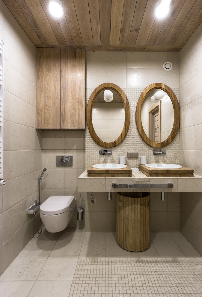 Photo of a mid-sized contemporary powder room in Moscow with a wall-mount toilet, beige tile, ceramic floors, a vessel sink and beige floor.