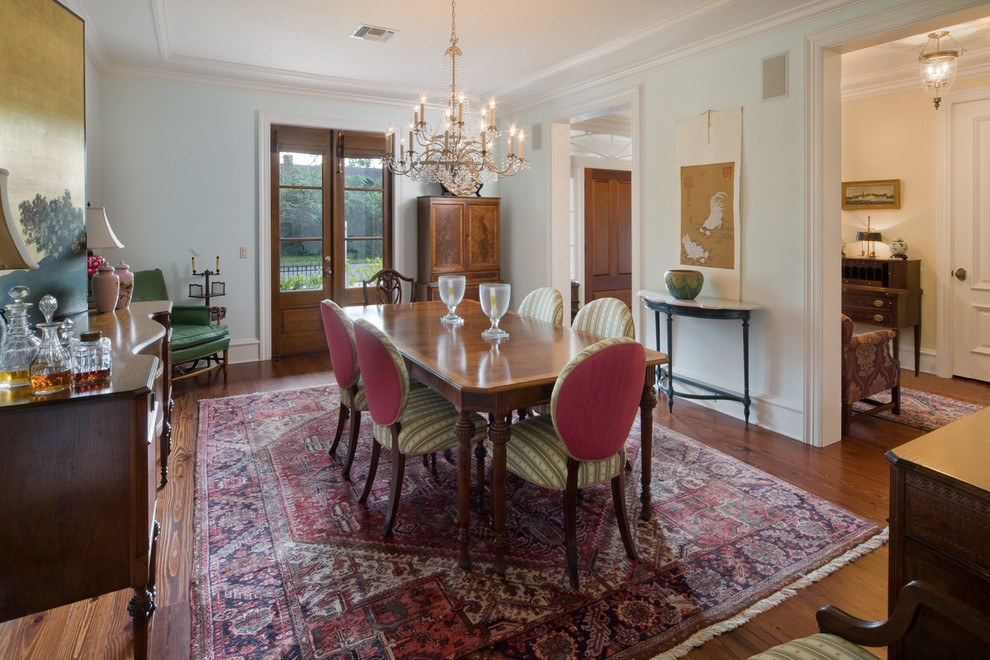 This is an example of a traditional separate dining room in Orlando with white walls and dark hardwood floors.