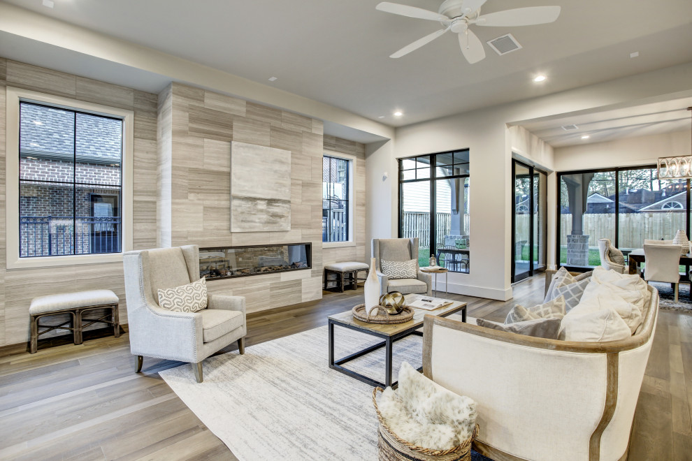 Diseño de sala de estar abierta contemporánea extra grande con paredes blancas, suelo de madera en tonos medios, todas las chimeneas, piedra de revestimiento y suelo marrón