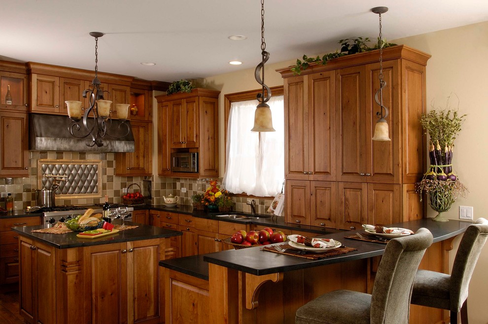 Photo of a mid-sized traditional u-shaped eat-in kitchen in Chicago with a double-bowl sink, raised-panel cabinets, medium wood cabinets, granite benchtops, beige splashback, ceramic splashback, panelled appliances, medium hardwood floors and multiple islands.