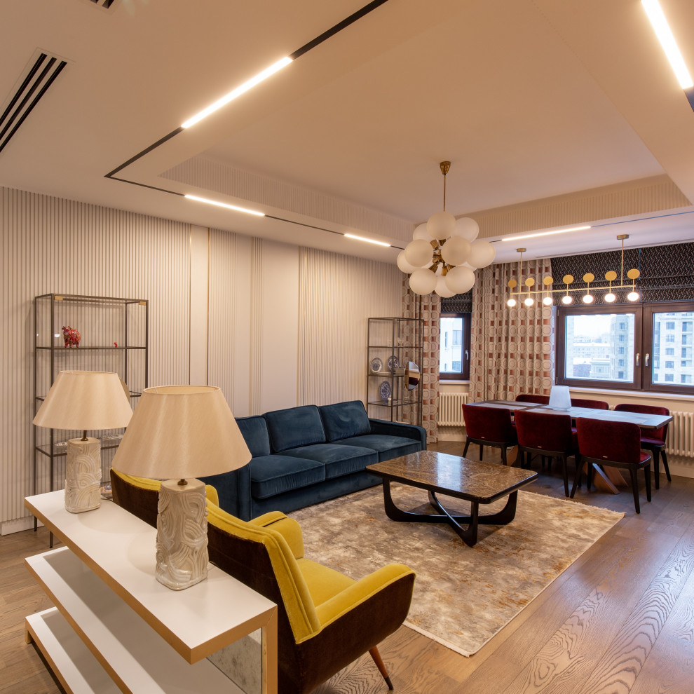 Esempio di un soggiorno design con pareti bianche, pavimento in legno massello medio, soffitto ribassato e boiserie
