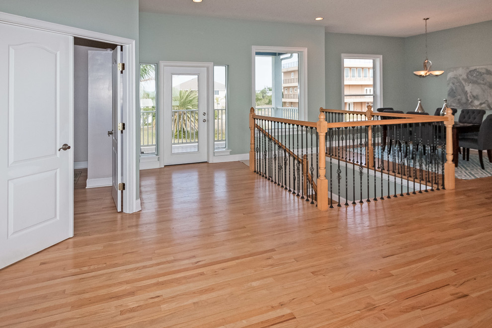 Inspiration for a large beach style foyer in Jacksonville with blue walls and light hardwood floors.
