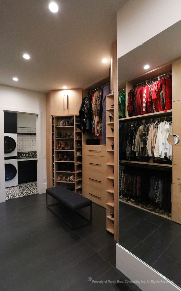 Свежая идея для дизайна: огромная гардеробная комната унисекс в стиле лофт с плоскими фасадами, светлыми деревянными фасадами, полом из керамогранита и черным полом - отличное фото интерьера