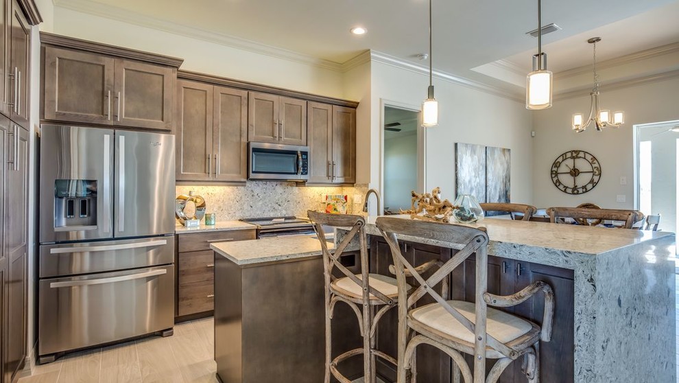 Example of a transitional ceramic tile and gray floor kitchen design with a drop-in sink, flat-panel cabinets, gray cabinets, quartz countertops, stainless steel appliances and an island