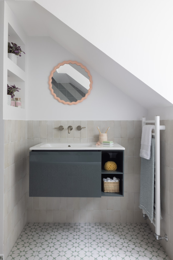 Inspiration for a contemporary bathroom in Surrey with flat-panel cabinets, grey cabinets, beige tiles, white walls, an integrated sink, green floors, white worktops, a single sink and a floating vanity unit.