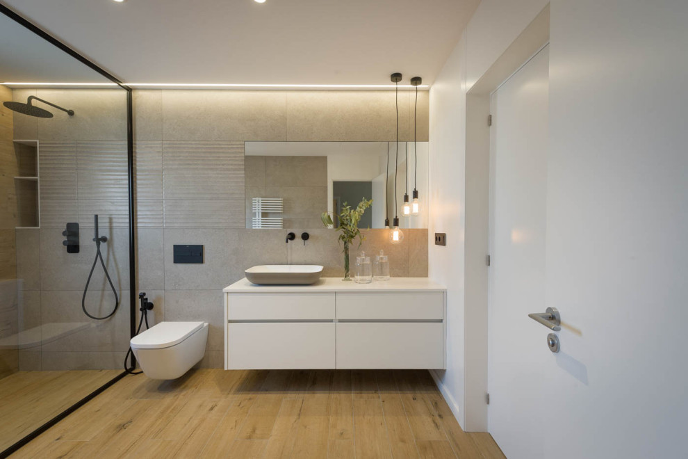 Photo of an expansive contemporary master bathroom in Other with flat-panel cabinets, a curbless shower, a wall-mount toilet, laminate floors and a wall-mount sink.