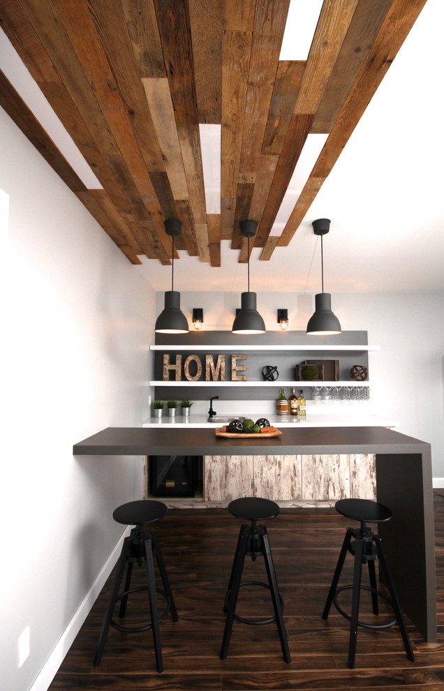 Design ideas for a mid-sized industrial galley home bar in Montreal with grey splashback, dark hardwood floors and distressed cabinets.
