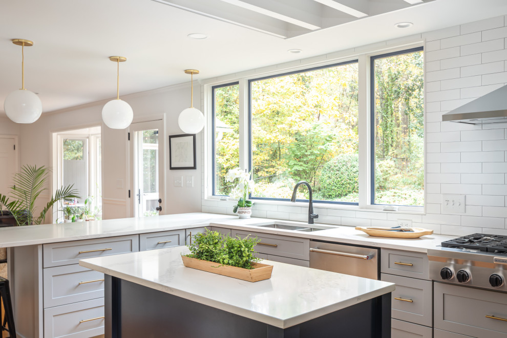 Inspiration for a mid-sized transitional u-shaped medium tone wood floor and brown floor open concept kitchen remodel in Raleigh with an undermount sink, recessed-panel cabinets, blue cabinets, quartzite countertops, white backsplash, subway tile backsplash, stainless steel appliances, an island and white countertops