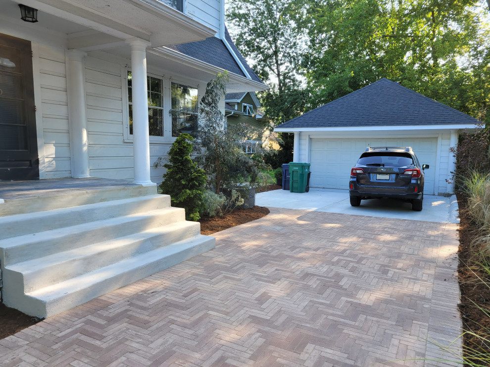 This is an example of a small traditional front yard full sun driveway in Chicago with a retaining wall and concrete pavers.