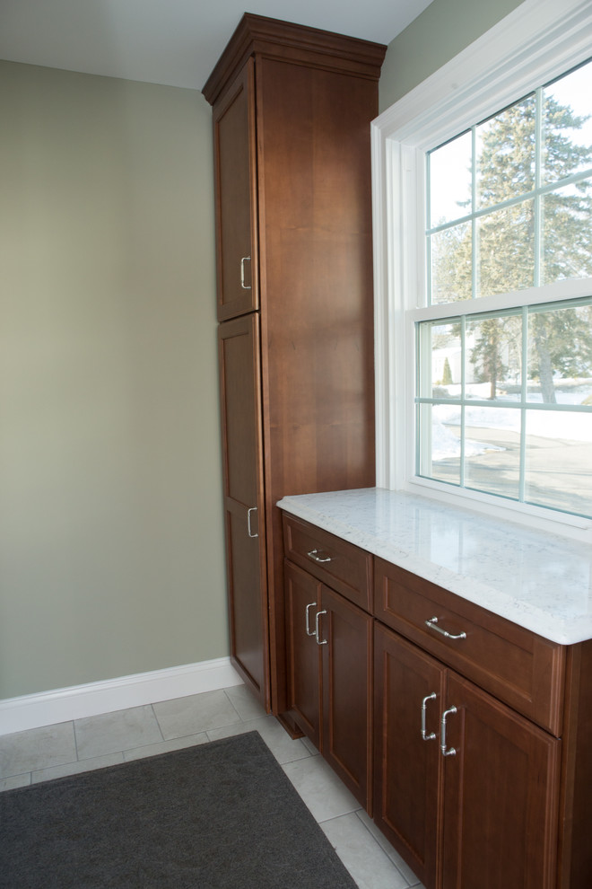 Mid-sized transitional l-shaped white floor and ceramic tile eat-in kitchen photo with quartz countertops, white countertops, an undermount sink, shaker cabinets, medium tone wood cabinets, white backsplash, porcelain backsplash, stainless steel appliances and a peninsula