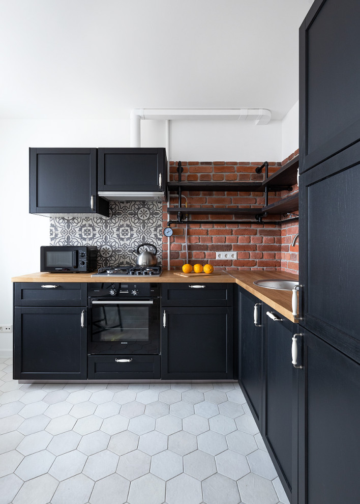 Photo of a contemporary l-shaped separate kitchen in Moscow with a drop-in sink, recessed-panel cabinets, black cabinets, brown splashback, black appliances, no island, white floor and brown benchtop.