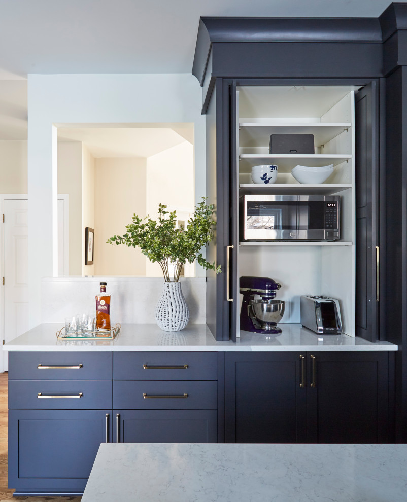 Inspiration for a large transitional medium tone wood floor and brown floor eat-in kitchen remodel in Chicago with an undermount sink, blue cabinets, quartz countertops, white backsplash, ceramic backsplash, stainless steel appliances, an island and white countertops