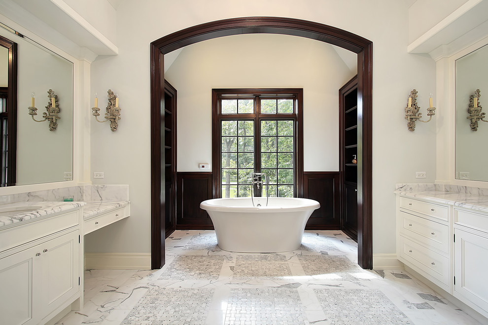 Inspiration for a traditional bathroom in New York with a vessel sink, shaker cabinets, white cabinets, marble benchtops, a freestanding tub, a wall-mount toilet, white tile and mosaic tile.