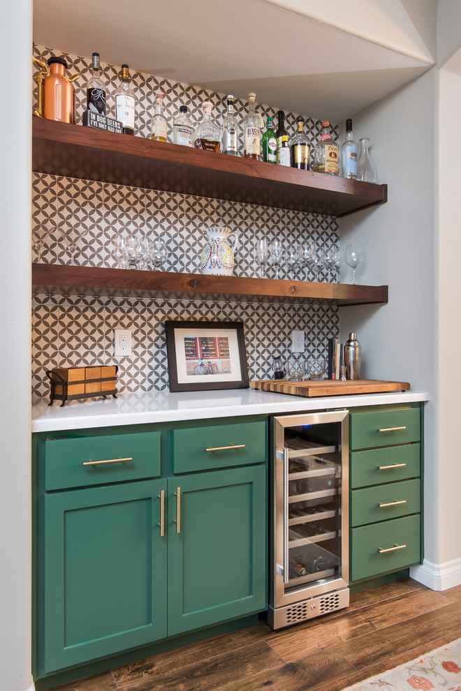 Example of a large transitional l-shaped brown floor home bar design in Los Angeles with shaker cabinets, green cabinets, quartz countertops, multicolored backsplash, porcelain backsplash, stainless steel appliances, an island and white countertops