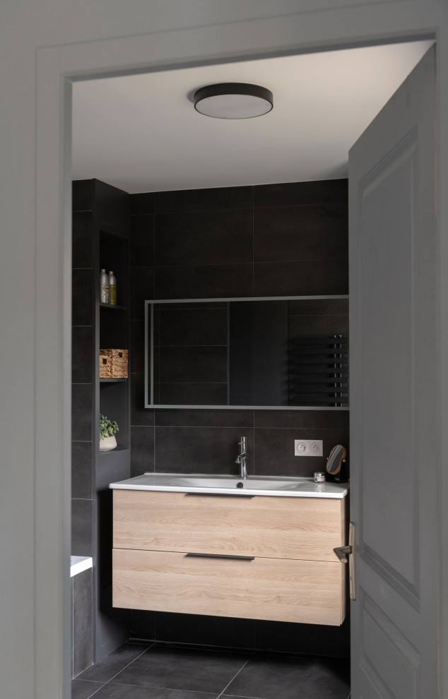 Inspiration for a mid-sized modern master black tile and stone slab slate floor, black floor and single-sink tub/shower combo remodel in Lyon with beaded inset cabinets, beige cabinets, an undermount tub, black walls, solid surface countertops, white countertops and a floating vanity