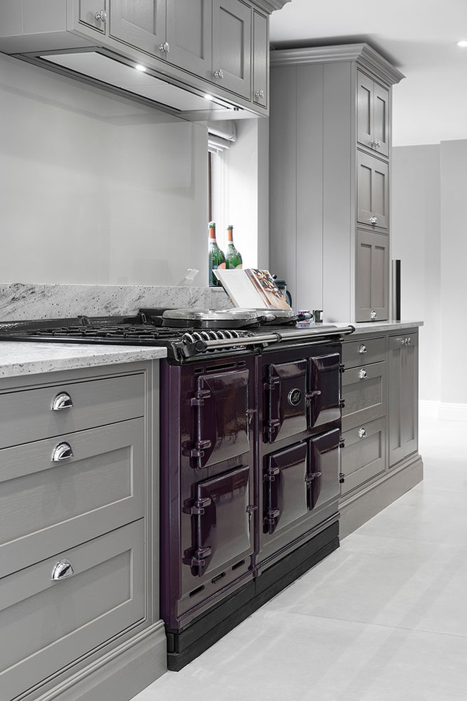Photo of an expansive contemporary u-shaped open plan kitchen in Surrey with a farmhouse sink, shaker cabinets, purple cabinets, granite benchtops, beige splashback, glass sheet splashback, stainless steel appliances, ceramic floors, with island, grey floor and multi-coloured benchtop.