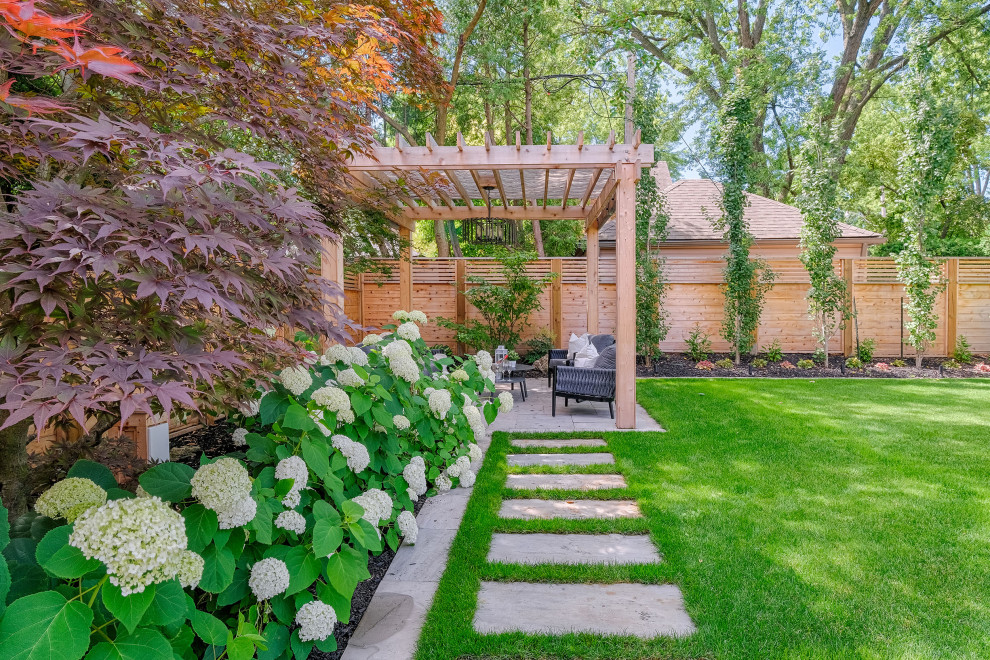 Ispirazione per un grande giardino tradizionale esposto in pieno sole dietro casa in estate con pavimentazioni in pietra naturale e recinzione in legno