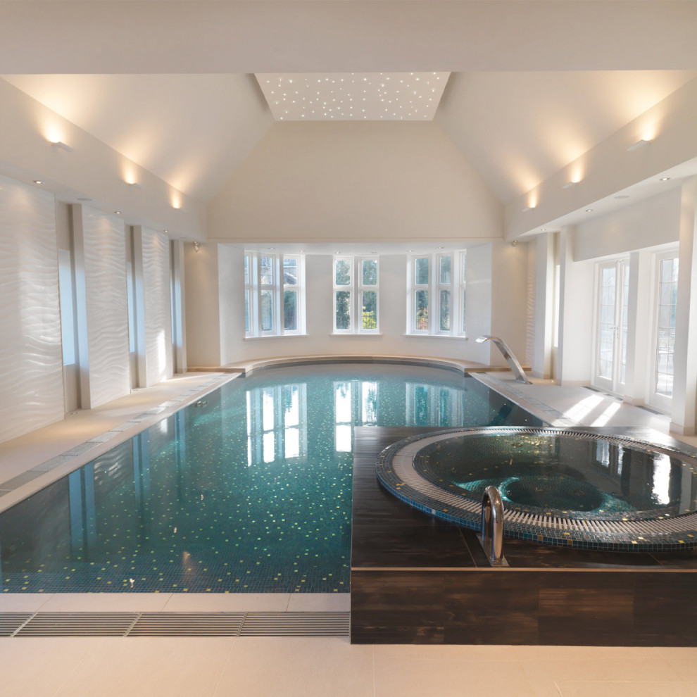 Large traditional indoor rectangular aboveground pool in Cheshire with a pool house and natural stone pavers.