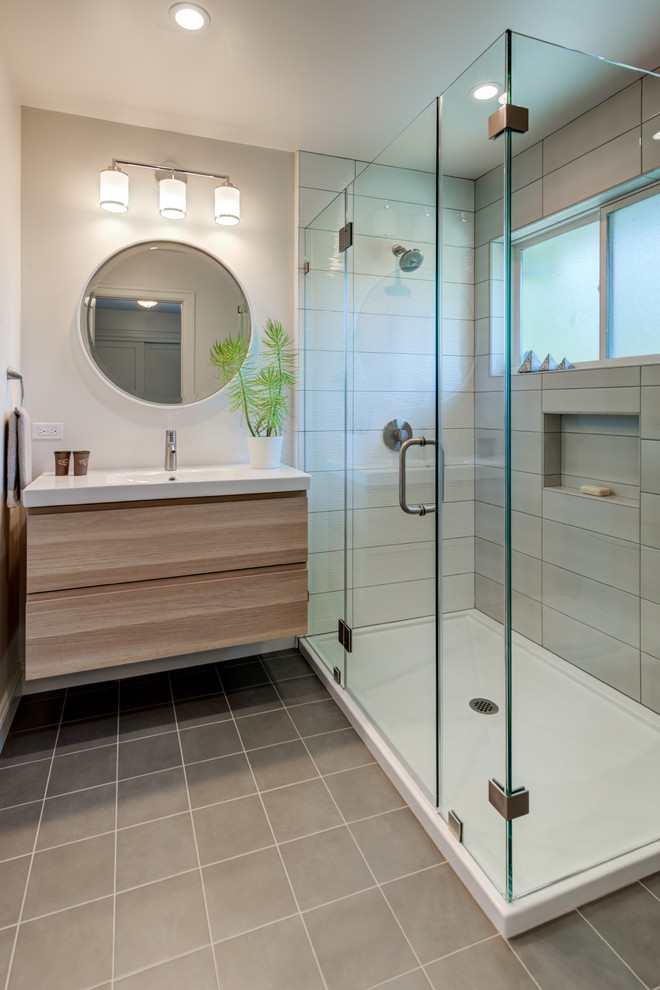 Design ideas for a contemporary bathroom in San Francisco with flat-panel cabinets, light wood cabinets, a corner shower, gray tile, beige walls, an integrated sink, beige floor, a hinged shower door and white benchtops.