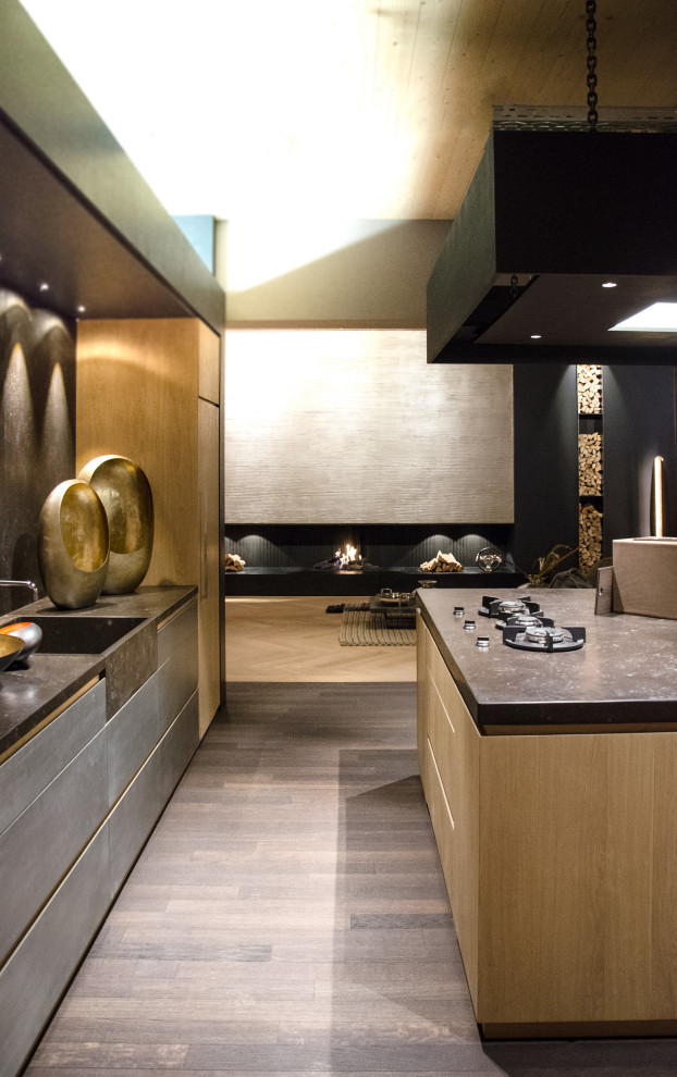 This is an example of a large contemporary galley open plan kitchen in Munich with a drop-in sink, flat-panel cabinets, grey cabinets, brown splashback, medium hardwood floors, with island and brown floor.