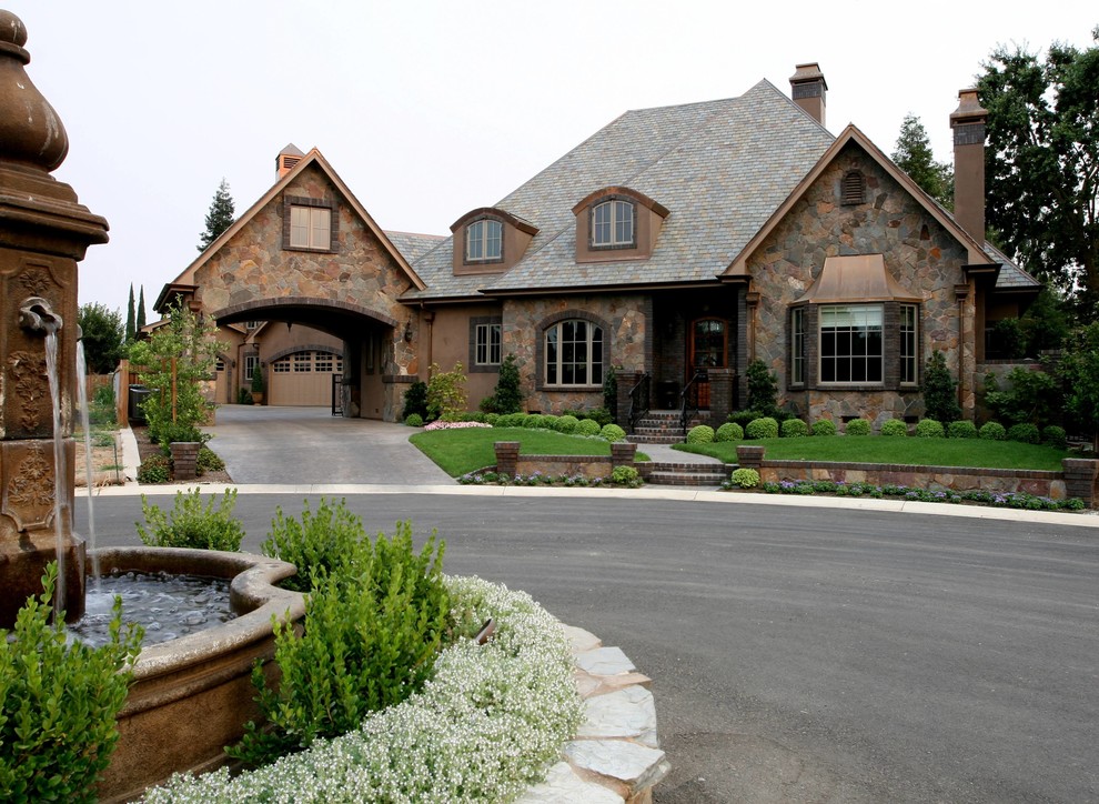 This is an example of a large traditional two-storey house exterior in Portland with stone veneer.