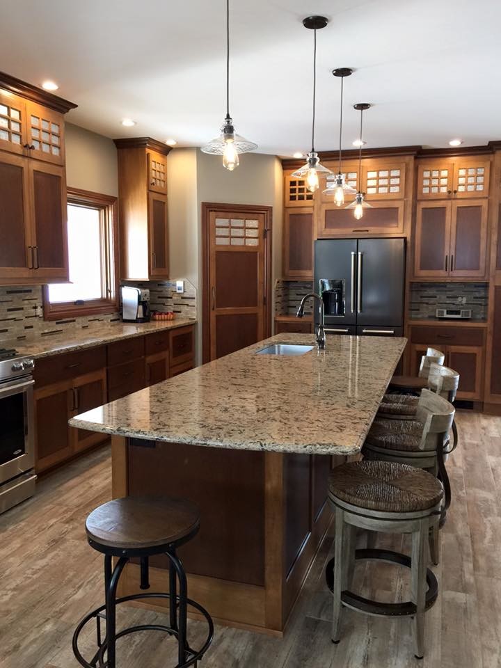 Eat-in kitchen - large transitional l-shaped eat-in kitchen idea with a single-bowl sink, brown cabinets, granite countertops, brown backsplash, stainless steel appliances and an island