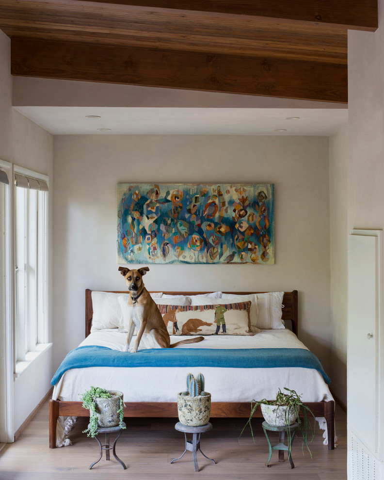Design ideas for a midcentury bedroom in Los Angeles with beige walls and medium hardwood floors.