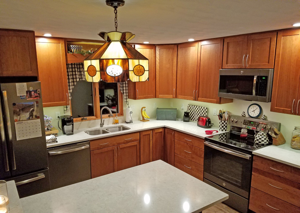 This is an example of a mid-sized transitional l-shaped eat-in kitchen in Other with an undermount sink, shaker cabinets, medium wood cabinets, quartz benchtops, stainless steel appliances, ceramic floors, with island, green floor and white benchtop.