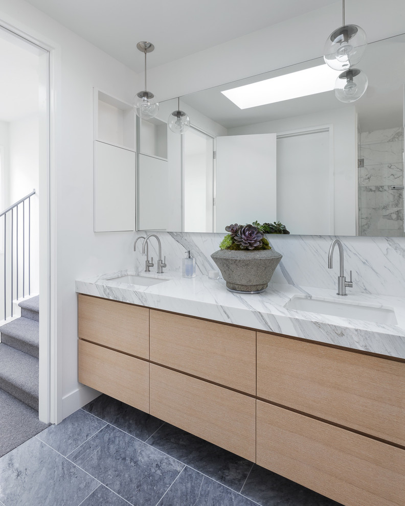 Photo of a contemporary bathroom in San Francisco with flat-panel cabinets, light wood cabinets, white tile, white walls, an undermount sink, grey floor and white benchtops.