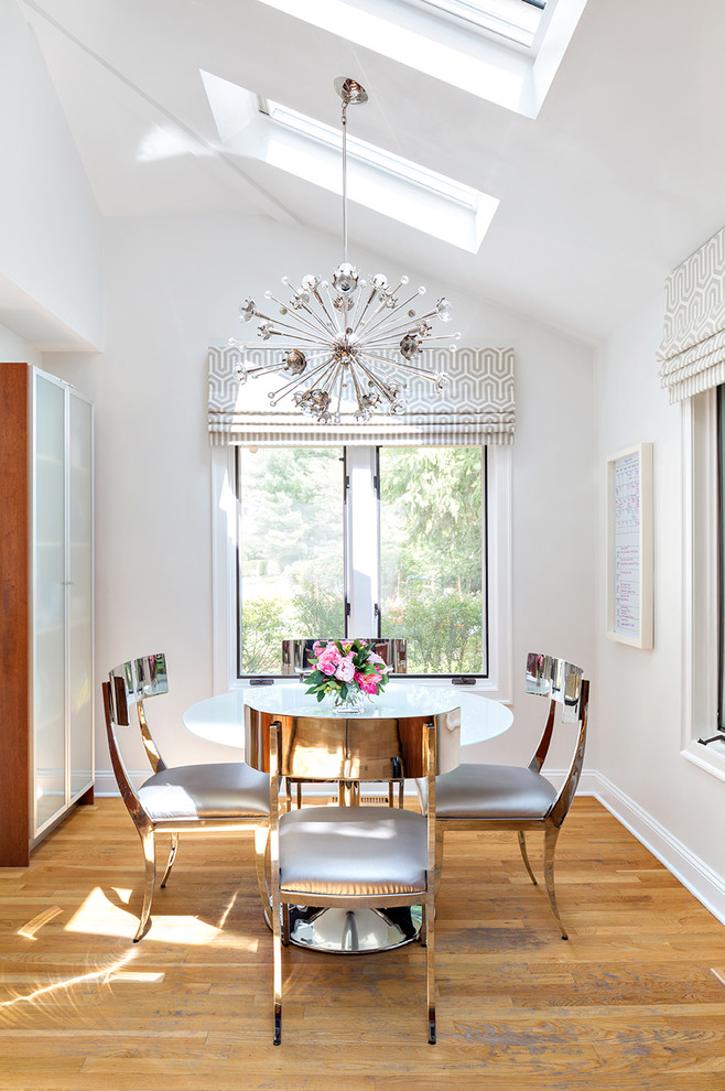 Inspiration for a dining room in New York with white walls and medium hardwood floors.