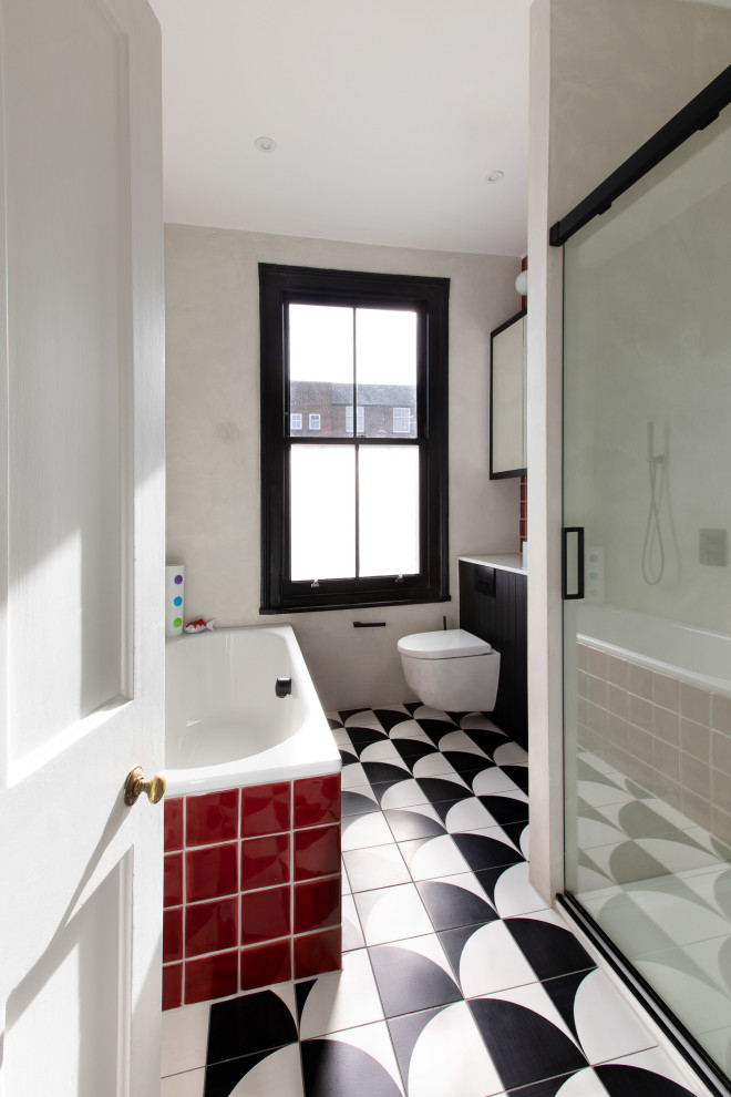 Exempel på ett litet modernt vit vitt badrum för barn, med luckor med glaspanel, svarta skåp, ett platsbyggt badkar, en öppen dusch, en toalettstol med hel cisternkåpa, röd kakel, tunnelbanekakel, grå väggar, klinkergolv i porslin, ett avlångt handfat, bänkskiva i kvartsit, flerfärgat golv och dusch med skjutdörr