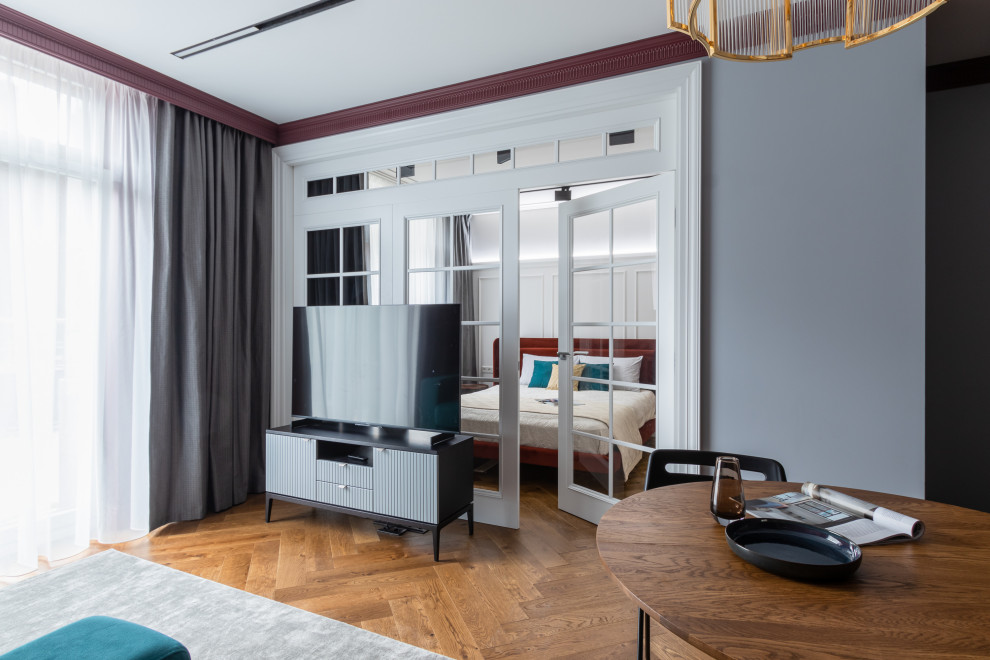 Imagen de salón clásico renovado pequeño sin chimenea con paredes rojas, suelo de madera en tonos medios, televisor independiente y suelo marrón