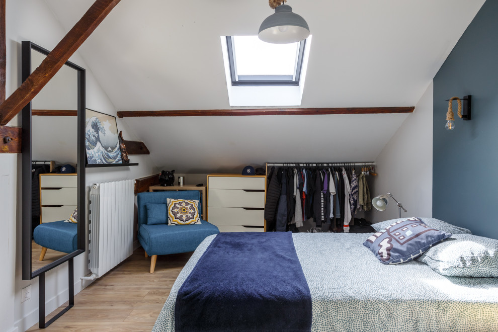 Foto på ett stort eklektiskt sovrum, med blå väggar och ljust trägolv
