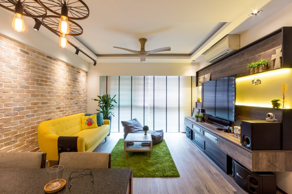 This is an example of a contemporary open concept living room in Singapore with white walls, medium hardwood floors, a wall-mounted tv and brown floor.