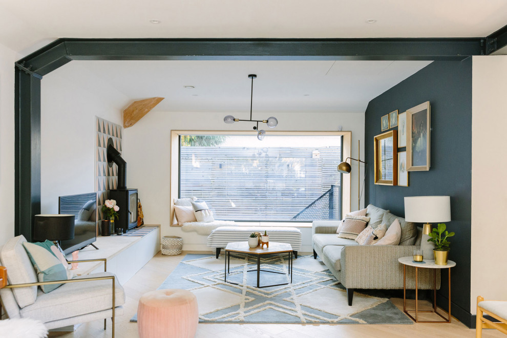 Diseño de salón actual con paredes blancas, suelo de madera clara, estufa de leña, televisor independiente, suelo beige y vigas vistas