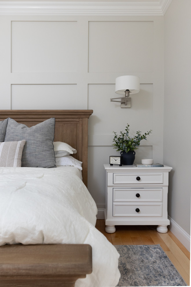 Inspiration pour une grande chambre parentale traditionnelle en bois avec un mur gris, parquet clair, une cheminée standard et un manteau de cheminée en bois.
