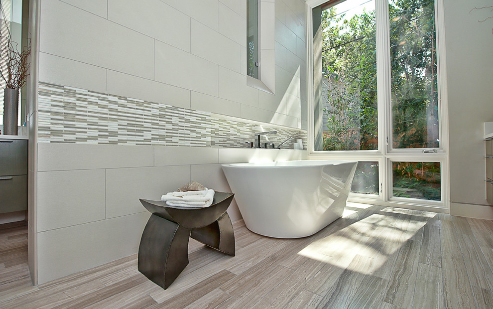 Photo of a contemporary bathroom in Austin with a freestanding tub and mosaic tile.