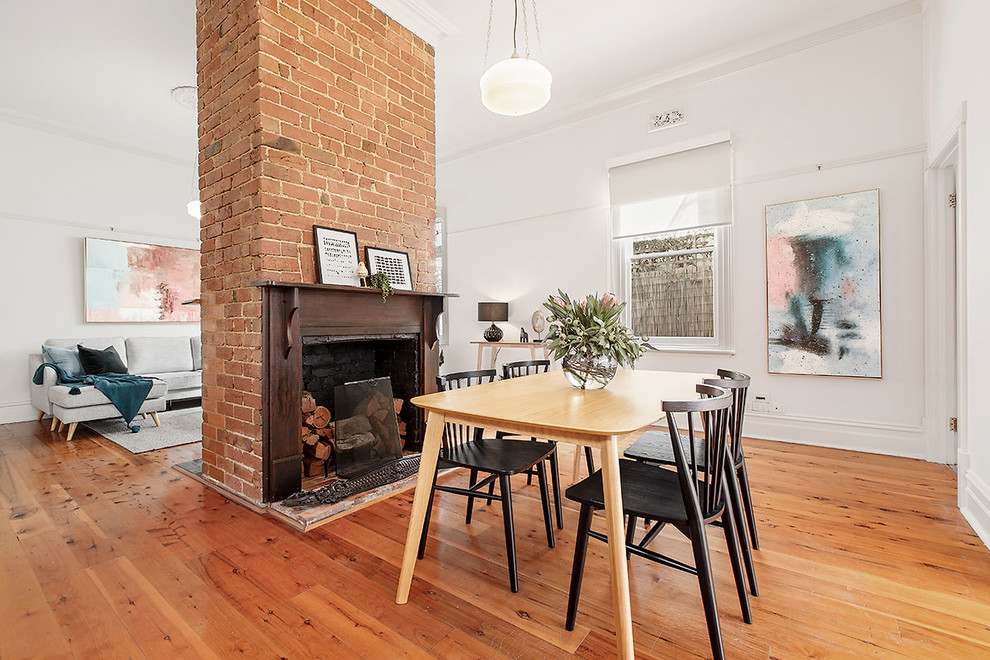 Inspiration for a transitional dining room in Melbourne with white walls, medium hardwood floors and brown floor.