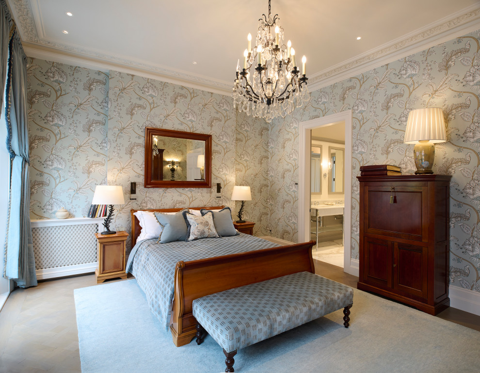 This is an example of a traditional master bedroom in London with multi-coloured walls, laminate floors, wallpapered walls and feature lighting.
