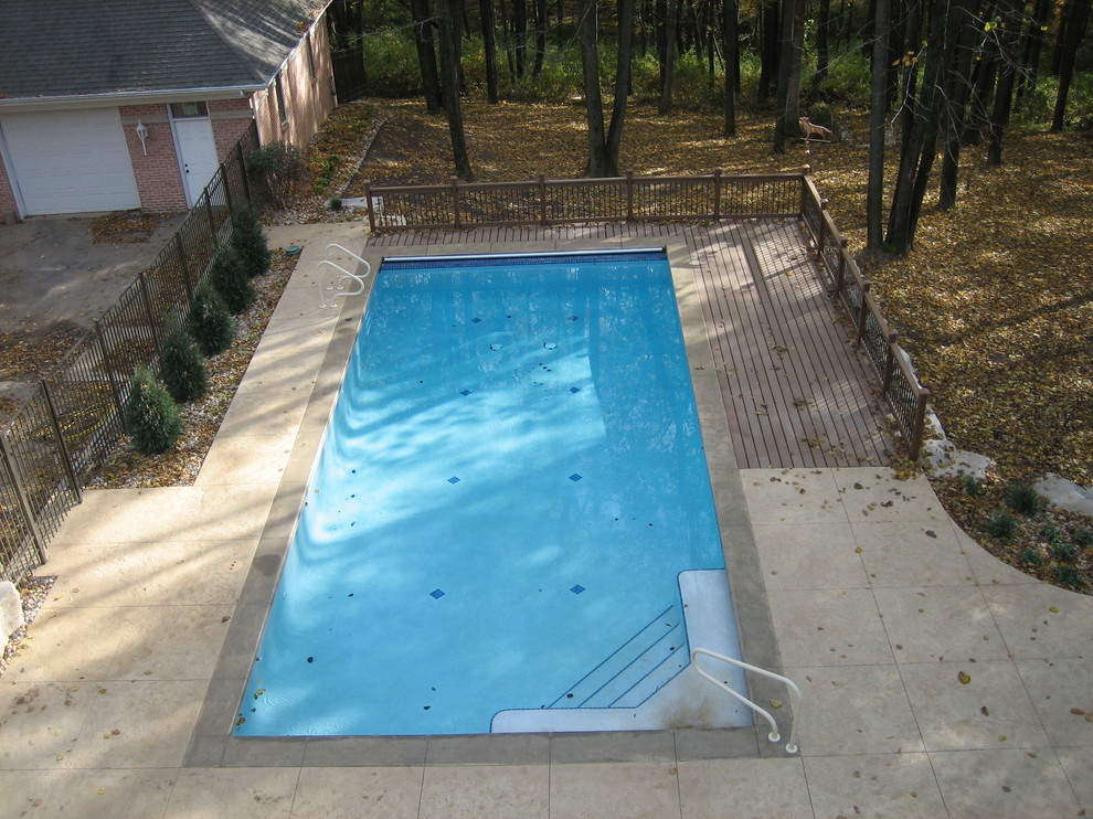 Example of a large transitional backyard concrete paver and rectangular natural pool house design in Cedar Rapids