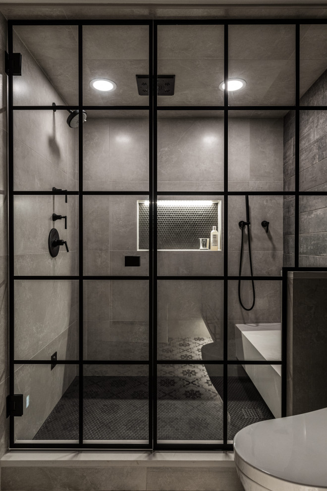 This is an example of a mid-sized industrial bathroom in Detroit with shaker cabinets, black cabinets, a one-piece toilet, beige tile, porcelain tile, grey walls, porcelain floors, with a sauna, an undermount sink, engineered quartz benchtops, multi-coloured floor, a hinged shower door and beige benchtops.