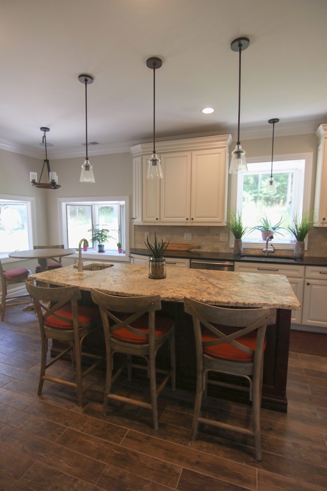 Mid-sized mountain style l-shaped dark wood floor and brown floor eat-in kitchen photo in New York with an undermount sink, raised-panel cabinets, white cabinets, quartzite countertops, beige backsplash, stainless steel appliances, an island and beige countertops