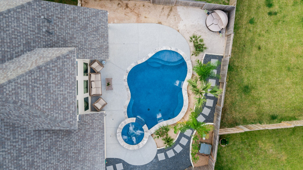 ヒューストンにあるラグジュアリーな中くらいなトロピカルスタイルのおしゃれな裏庭プール (庭内のプール、デッキ材舗装) の写真