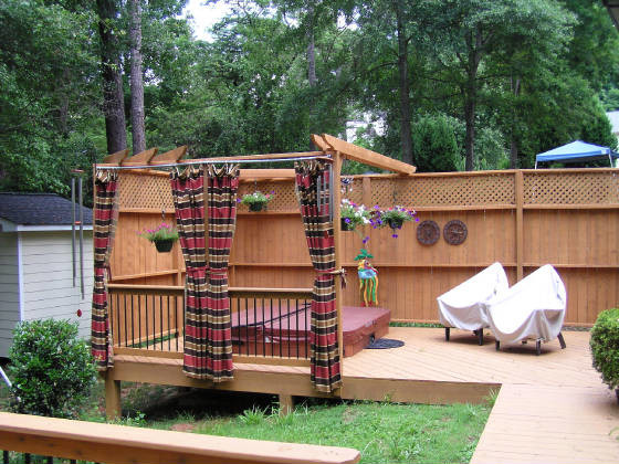 Large country backyard deck in Atlanta with a water feature and a pergola.