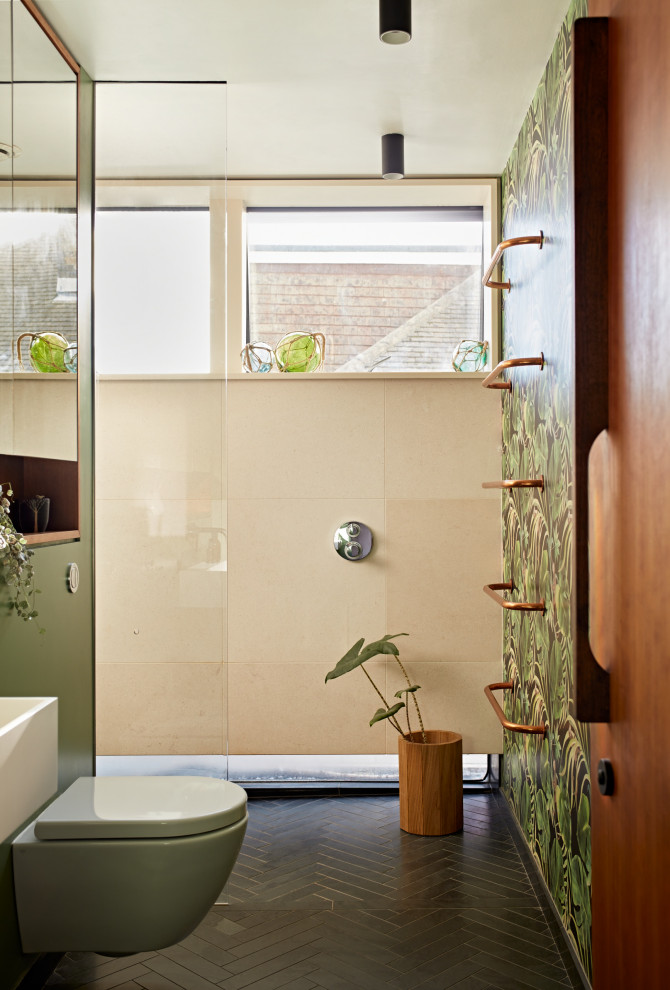 This is an example of a mid-sized tropical 3/4 wet room bathroom in Sussex with glass-front cabinets, green cabinets, a wall-mount toilet, limestone, slate floors, a drop-in sink, wood benchtops, black floor, brown benchtops, a single vanity, a built-in vanity, wallpaper and green tile.